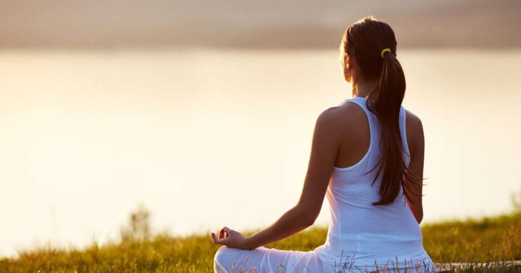 A woman performing meditation for mental health